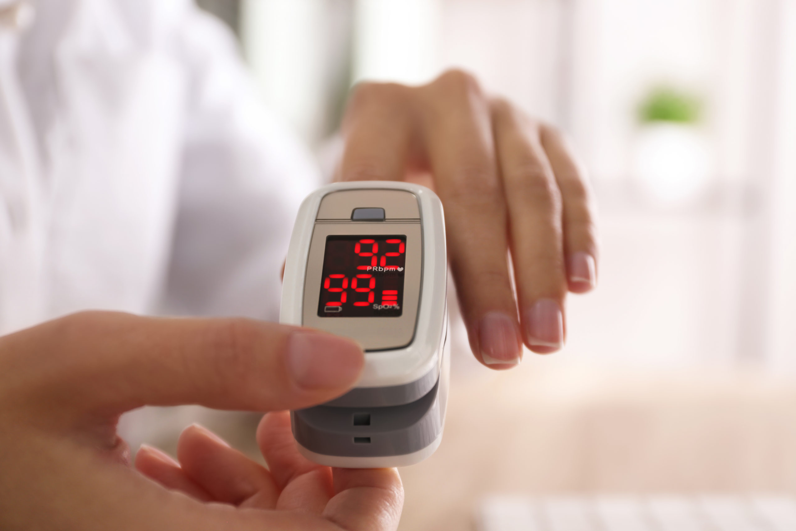 Woman Measuring Oxygen Level With Modern Fingertip Pulse Oximeter At