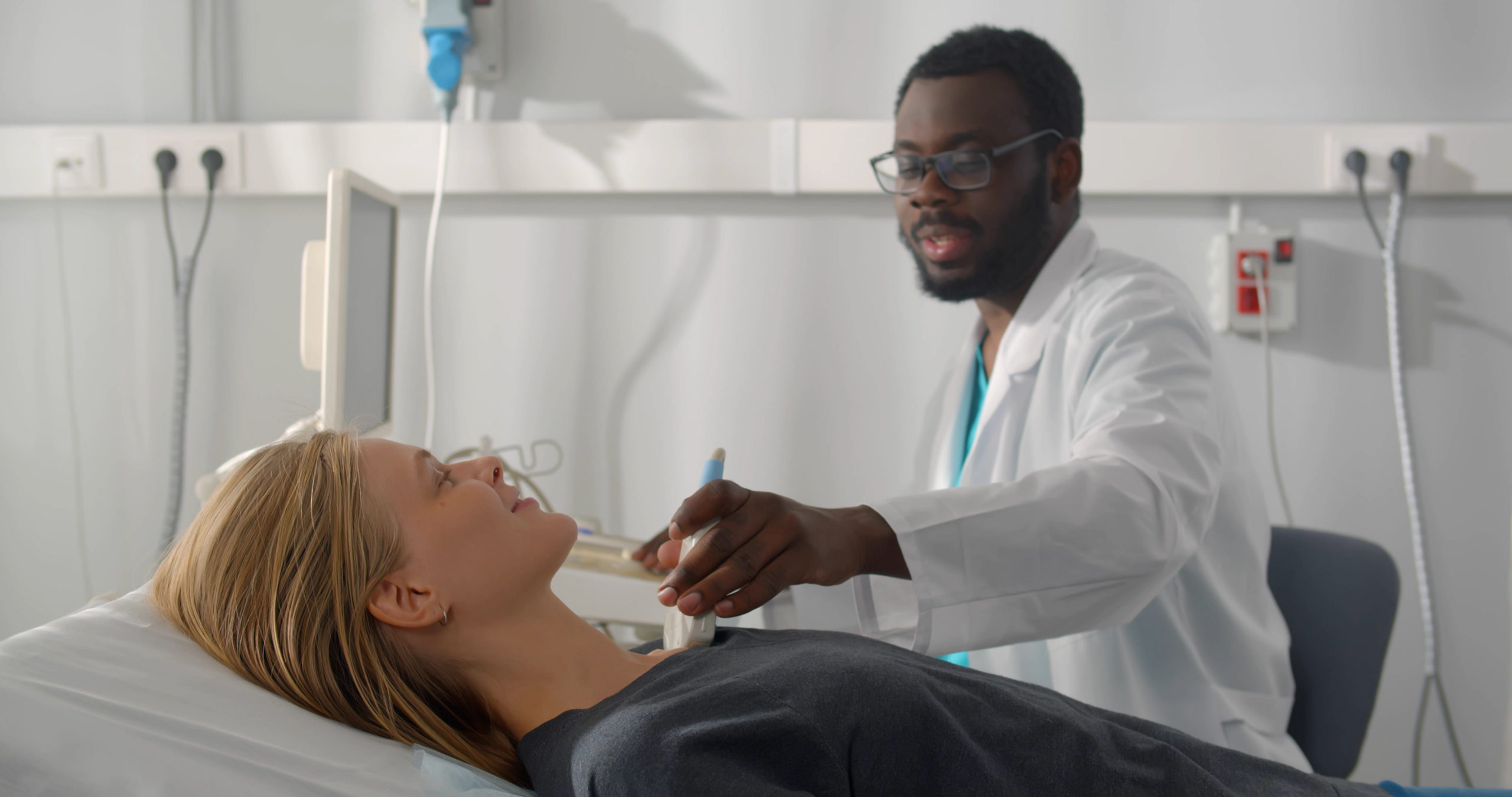 African Man Endocrinologist Making Ultrasonography To Female Patient In Ultrasound