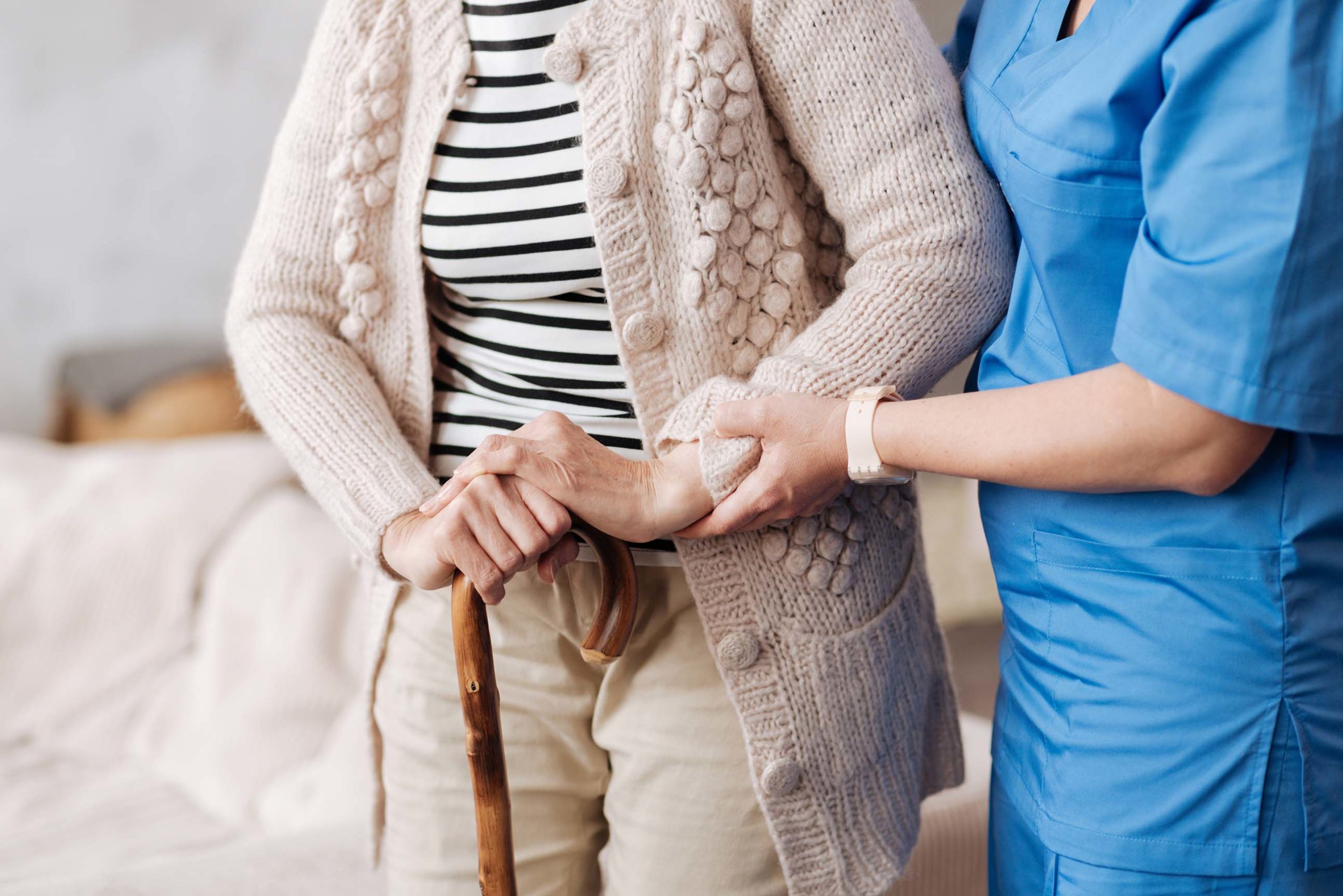 Doctor helping elderly patient stand