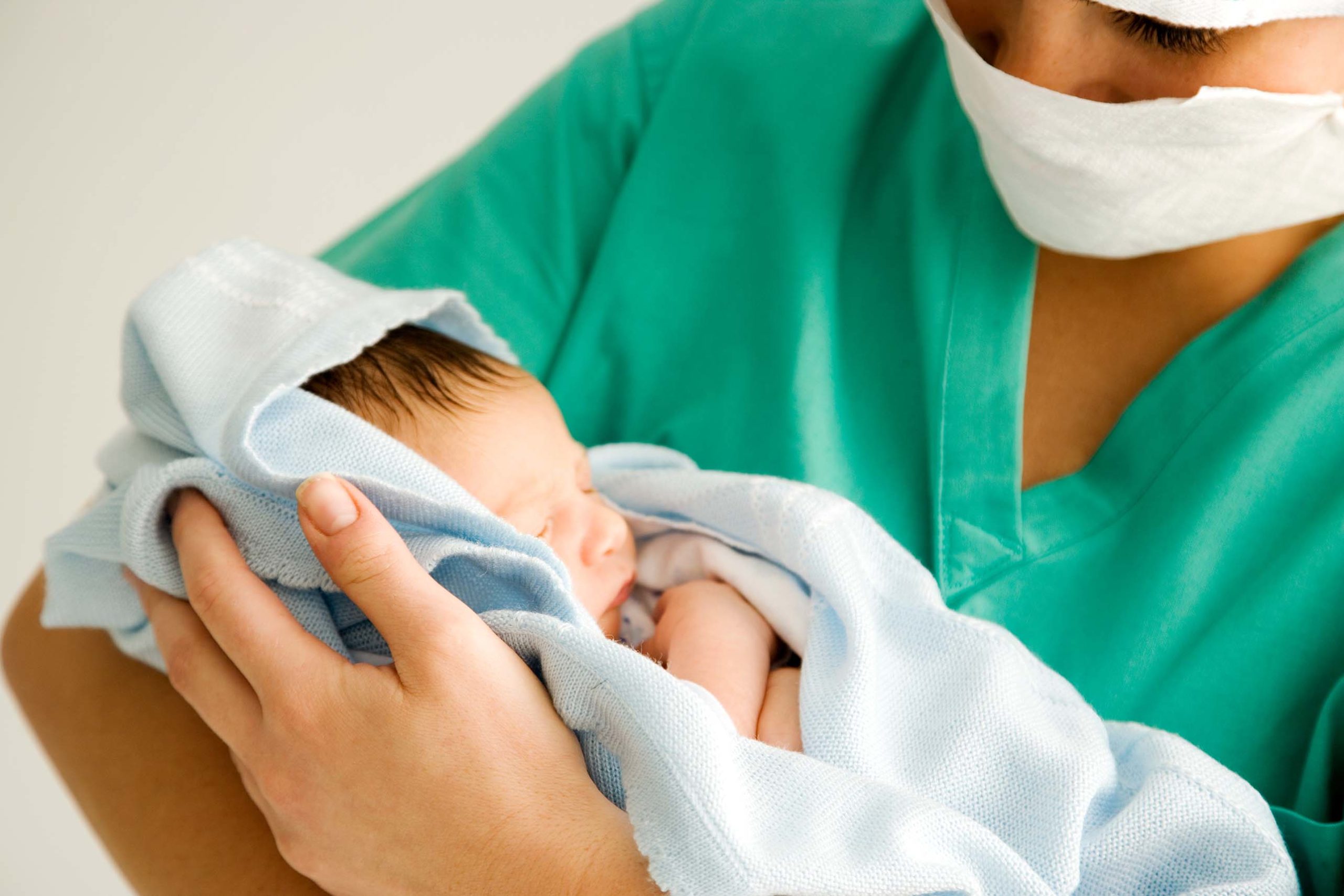 nurse holding a newborn